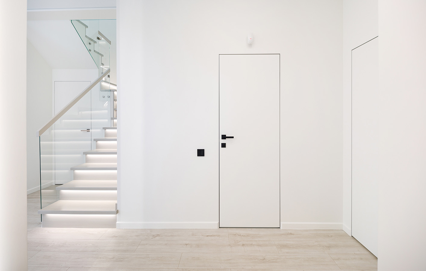 Rahmenlose weiße Tür – Minimalismus für moderne Räume Moderne weiße, rahmenlose Tür in minimalistisch gestaltetem Flur